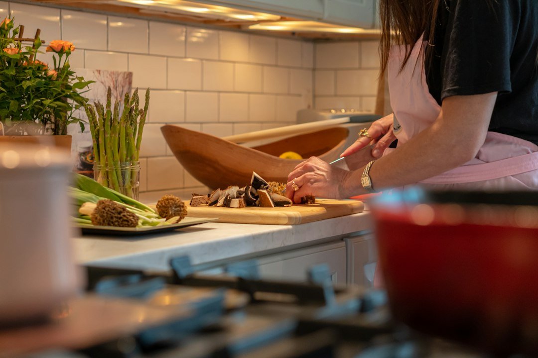 Hands preparing vegetables together in a home kitchen